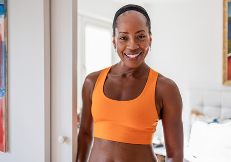 Portrait of smiling african american woman standing in fitness studioの写真素材