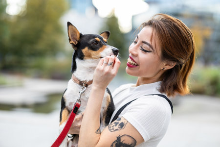 Beautiful young woman with a dog in the city. Portraitの写真素材