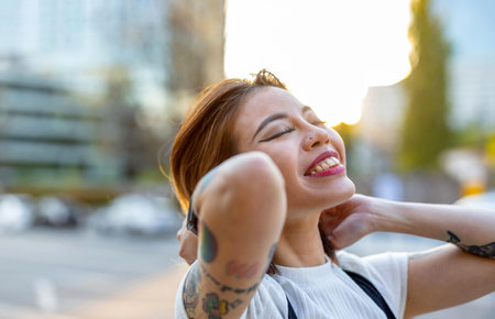 Portrait of a young beautiful woman with tattoo on her arm outdoors
