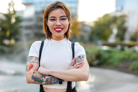 Portrait of a beautiful woman with tattoos on her armsの写真素材
