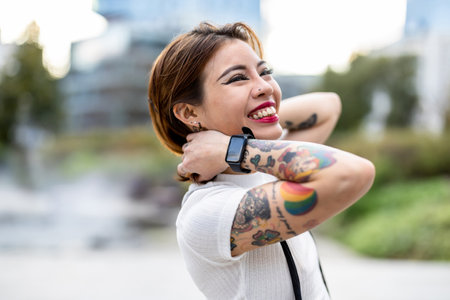 Portrait of a beautiful woman with tattoos on her arms and a smartwatchの写真素材