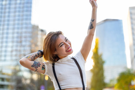 Beautiful young woman with tattoos in the streets of a cityの写真素材