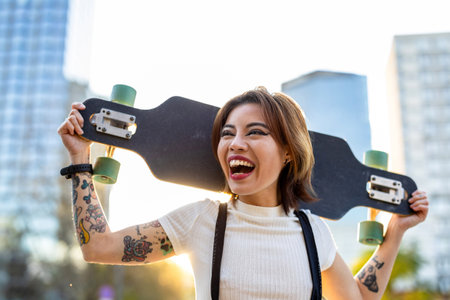 Young beautiful hipster woman with longboard on the street in the cityの写真素材