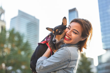 Beautiful young woman with her dog in an urban context.の写真素材