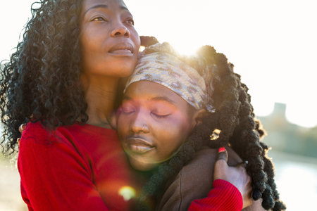 Portrait of mother and daughter embracing each other on a sunny dayの写真素材