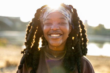 Portrait of a smiling african american woman with dreadlocks outdoorsの写真素材