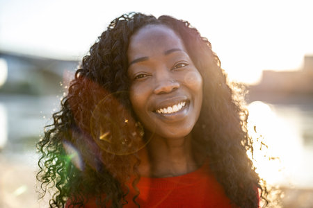 Close up portrait of a beautiful african american woman smiling outdoorsの写真素材
