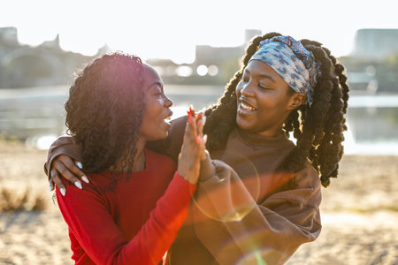 Portrait of two african american women having fun on the beachの写真素材