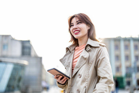 Portrait of beautiful young woman using mobile phone in the city.の写真素材