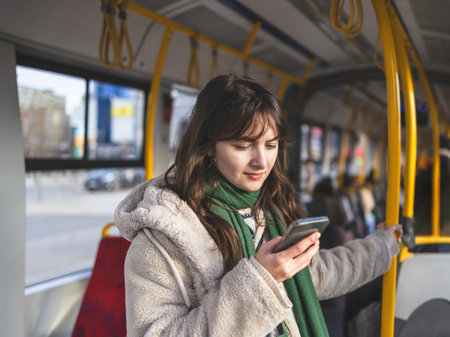 young beautiful woman in the city bus using mobile phone and textingの写真素材