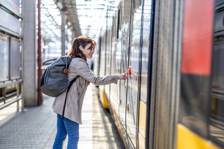 Young woman with backpack on the platform of a train station. Travel concept.の写真素材