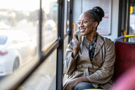 Portrait of smiling senior woman using mobile phone while sitting in busの写真素材