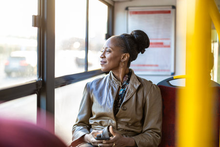 Portrait of smiling african american woman sitting in public transportの写真素材