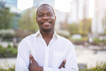 Portrait of happy african american man with arms crossed in cityの写真素材