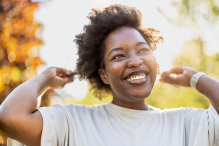Portrait of a smiling young African American woman in the parkの写真素材