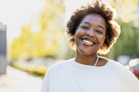 Portrait of a beautiful young african american woman smiling outdoorsの写真素材
