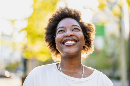 portrait of young african american woman smiling in the cityの写真素材