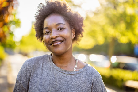Portrait of a beautiful young african american woman smiling outdoorsの写真素材
