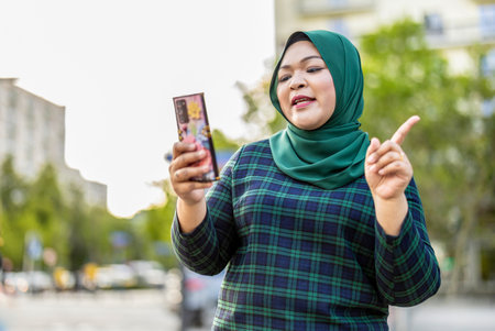 Portrait of asian muslim woman taking selfie with mobile phone