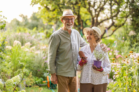 Portrait of happy senior couple gardening together in the garden at homeの写真素材
