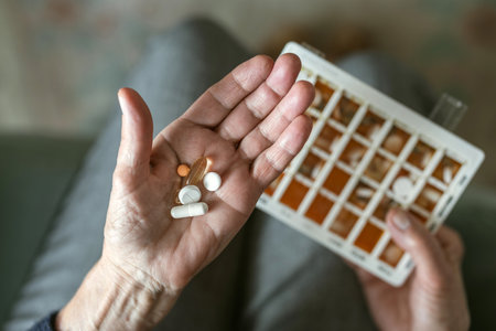 Closeup of senior woman holding pills in hand, on blurred backgroundの写真素材