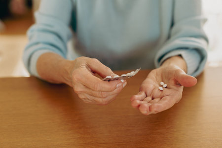 Close-up of senior woman holding pills. Focus on hand.の写真素材