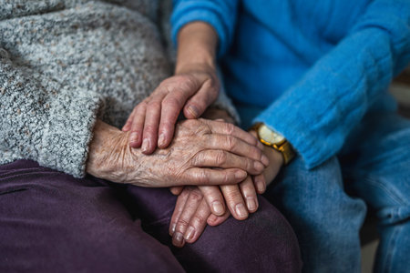 Close-up of senior woman holding hands of her caregiver in nursing home