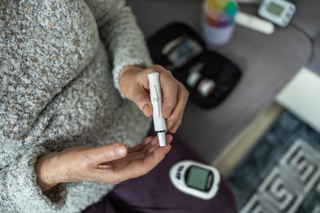 Senior woman measuring blood sugar level with glucometer at home