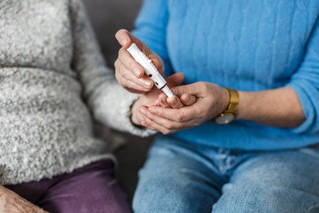 Close up of senior woman checking blood sugar level with glucometer