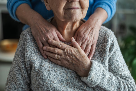 Close up of senior woman holding her hands on her chest at homeの写真素材