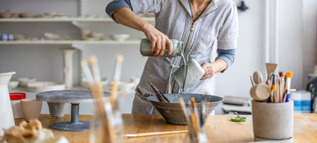 Potter working in his pottery workshop, close-up.