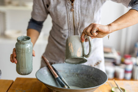 Close-up of a woman pouring water on a pottery bowl