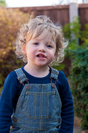 portrait of cute blond toddler in gardenの写真素材