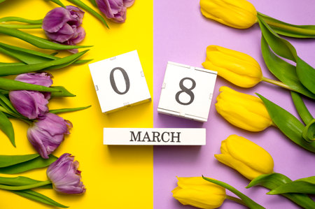 Women's day flat lay in yellow and purple colors. 8 march calendar near a bunch of flowers