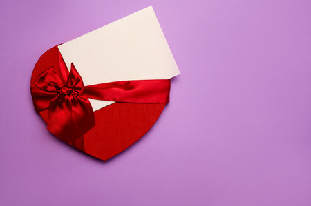 Valentine's day background with red heart an card on purple backgroundの写真素材