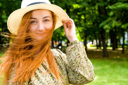 Sunny summer portrait of happy caucasian girl with hat on and place for textの写真素材