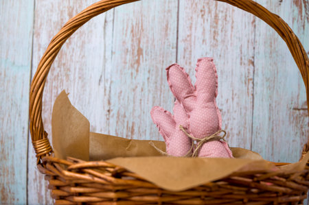 Closeup of pink toy bunnies in the basket full of colorfull eggs. Happy easter banner with place for textの写真素材