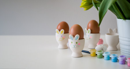Wooden Easter eggs, multi-colored paints and brushes for decorating souvenirs for celebration of Easter. Artistic work, handmade, creativity with children for decoration on Easter.の写真素材