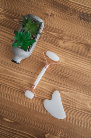 Top view on jade roller,gua sha scraper on the table.Wellness and selfcare.Natural skin treatmentの写真素材