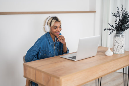 Young college student learning athome. girl with laptop sitting at the desk listening to the lecture, conference etcの写真素材