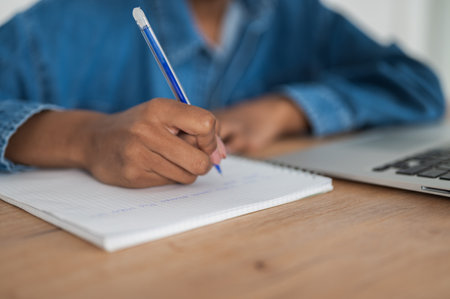 Unrecognizable Student preparing for college test, exam, writing notes, making summary for class report. Learning workplace table, hands with pen close upの写真素材
