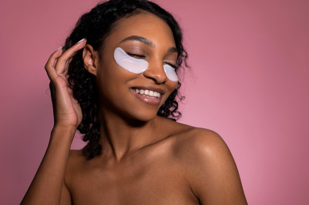 Beauty skin routine. Studio shot of cute African American girl smiling with patches under eyesの写真素材