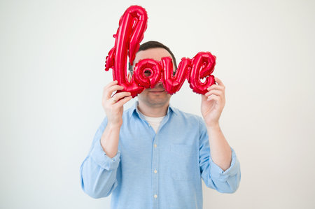 Valentines day concept. Portraint of happy man looking through balloonの写真素材