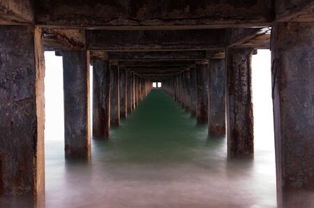 Tunnel effect with emerald colored water at the beach in the eveningの写真素材