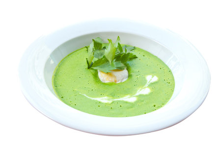 green vegetable soup with parsley, in a restaurant, on a table-clothの写真素材