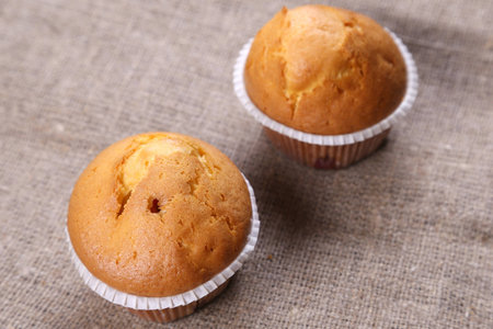 few fresh muffins are on textile