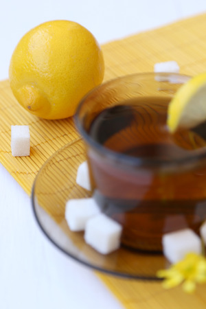 cup with fresh tea and lemon on a yellow backgroundの写真素材