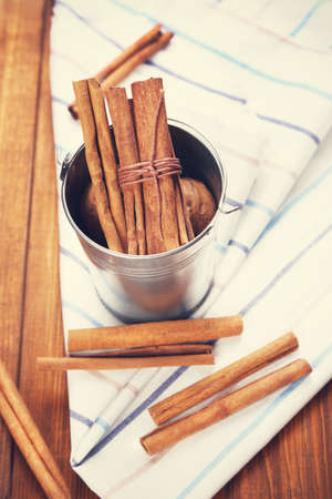  sticks of cinnamon are in a decorative bucket, on textileの写真素材