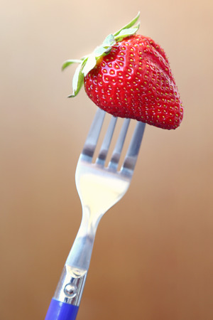 fresh ripe red strawberry on metallic forkの写真素材