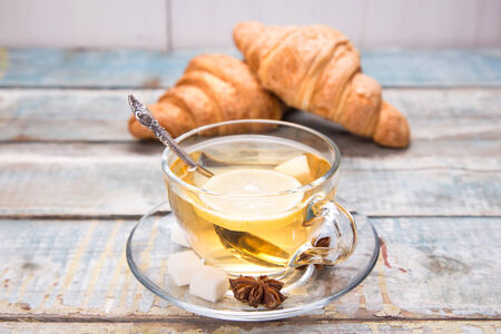 few fresh croissant,hot tea with a lemon in a studioの写真素材